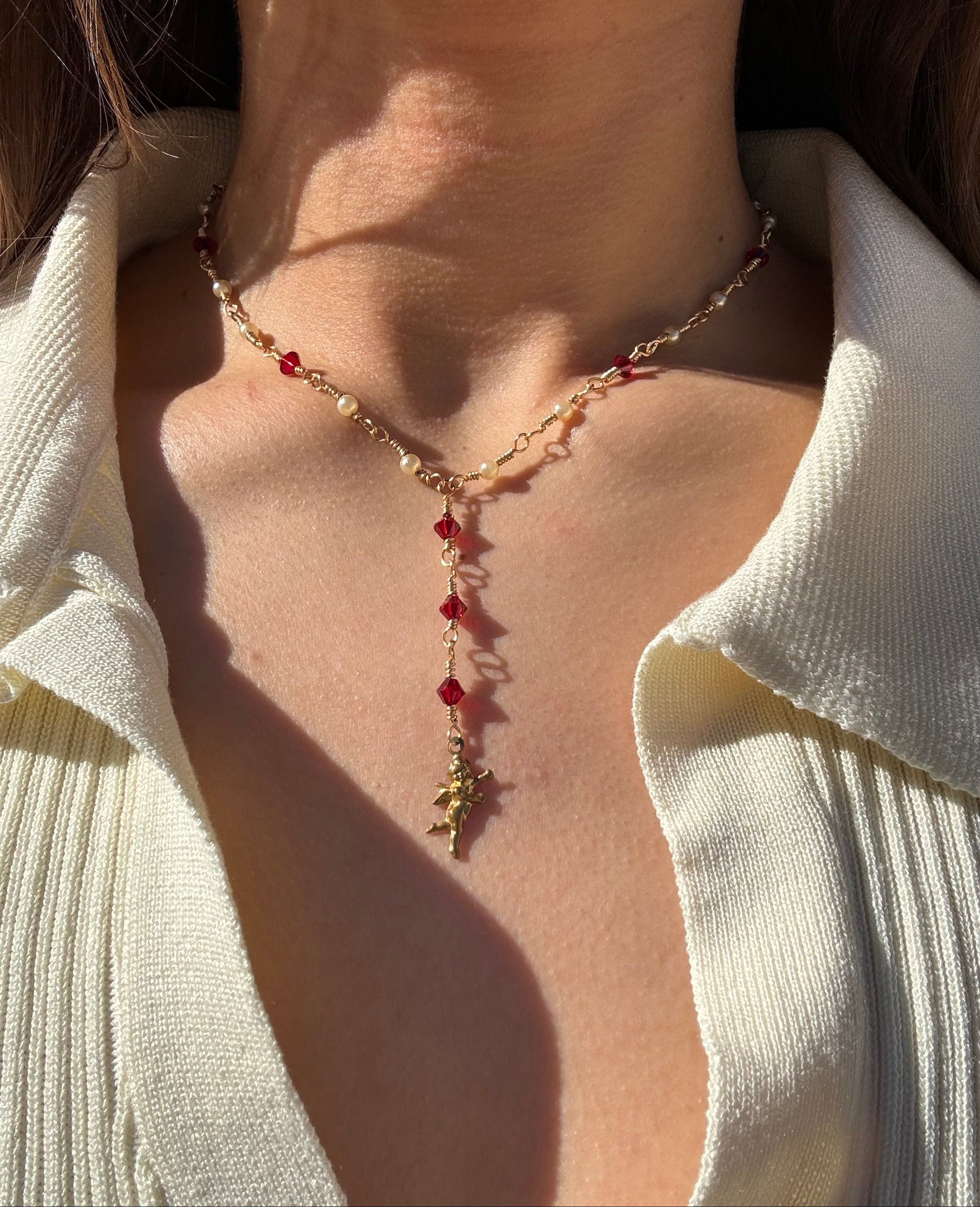 Necklace handmade gold non tarnish wire with red glass crystal beads, white pearl colored bead and a brass cupid